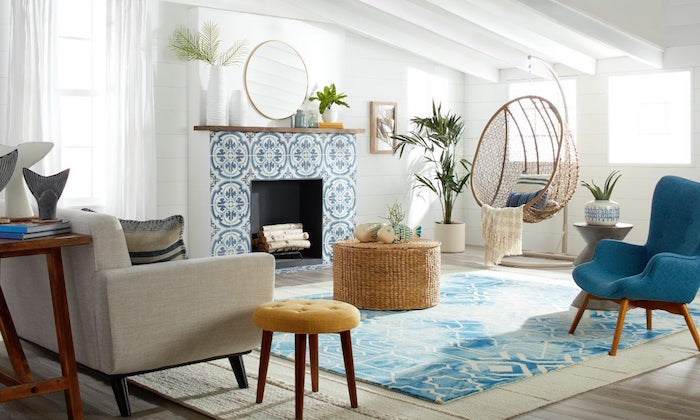 blue armchair and carpet in front of fireplace covered with blue and white tiles coastal living room with white shiplap walls