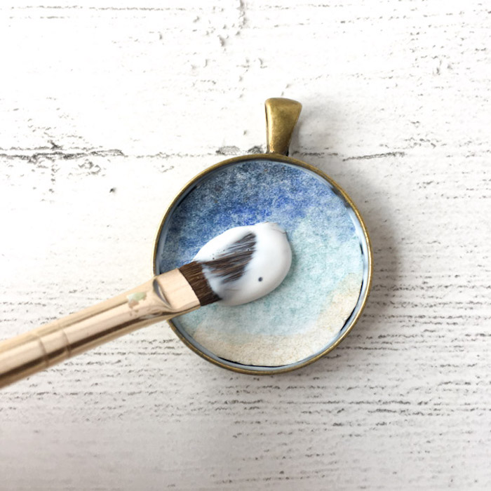 bronze vintage necklace pendant jewelry making for beginners blue watercolor paper placed on the bottom
