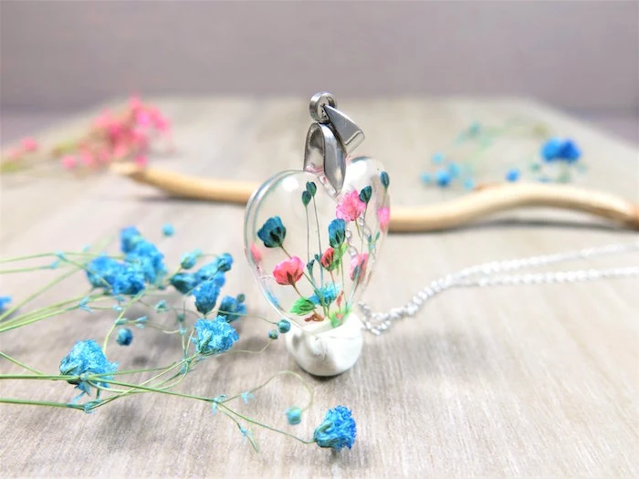 clear necklace pendant in the shape of a heart with dried flowers inside in pink blue green resin earrings