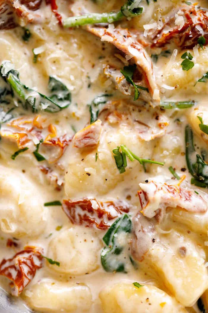 close up photo of creamy tuscan gnocchi with sun dried tomatoes basil leaves healthy gnocchi recipes