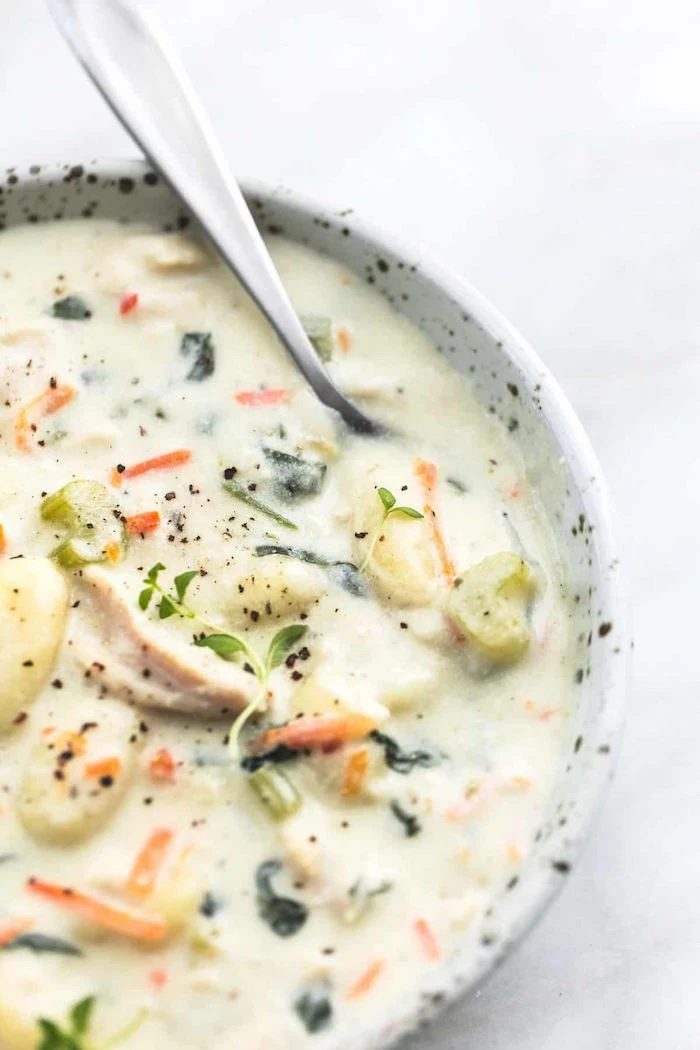 creamy gnocchi soup homemade gnocchi recipe with chicken carrots poured into white bowl spoon on the side