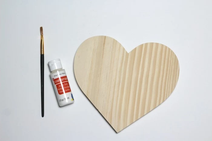 cute things to get your boyfriend for valentines day wooden heart with glue and paintbrush placed on white surface
