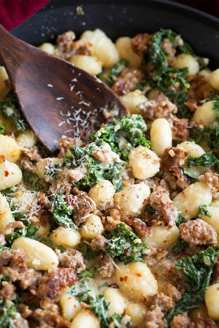 gnocchi cooked in black pan stirred with wooden spoon easy gnocchi recipe with italian sausage and kale