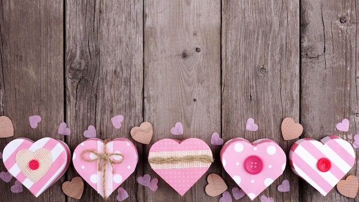 happy valentines day wooden background five pink boxes in the shapes of hearts with different decorations on them buttons and twine