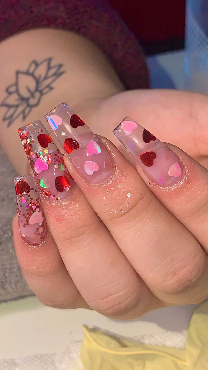 long coffin nails made with acrylic valentines nails red and pink hearts and glitter on them