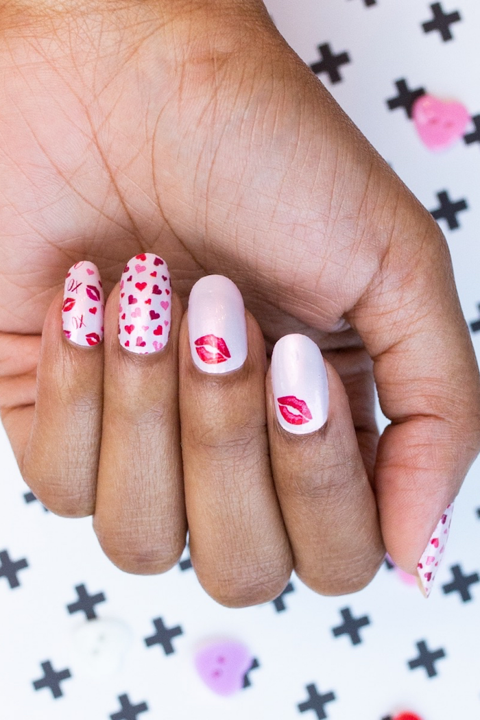 medium length squoval nails with light pink nail polish valentines day nails hearts and kisses drawn on them in red and pink