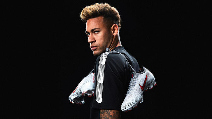 neymar jr turning to the camera wearing black nike t shirt nike wallpaper nike boots around his shoulder tied together black background