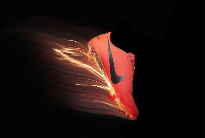 orange nike football boot with black nike logo on it cool nike wallpapers photographed on black background