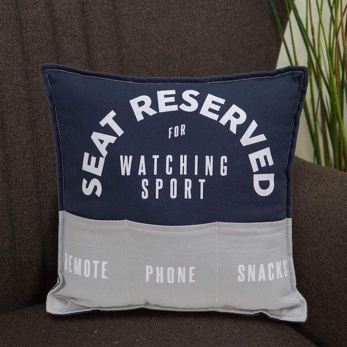 pillow in gray and navy blue what to get a guy for valentines day seat reserved for watching sport written on it pockets for remote phone snacks