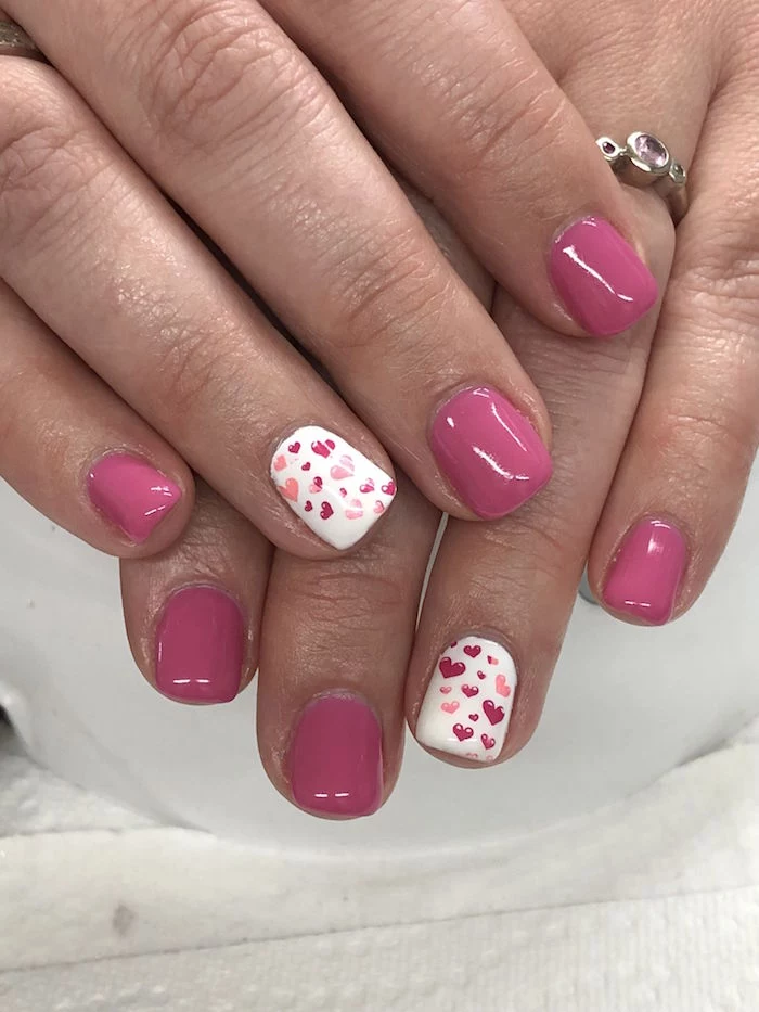 pink and white nail polish on short squoval nails valentines nails red and pink hearts drawn on ring fingers