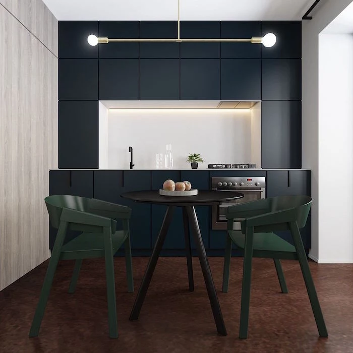 small kitchen remodel dark navy blue cabinets white backsplash with led lights wooden table with dark green chairs