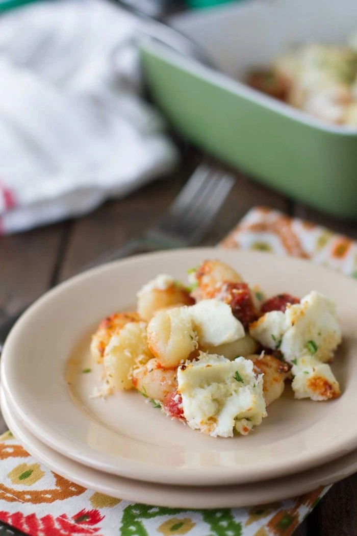 small white plate with baked gnocchi with ricotta cheese best gnocchi recipe colorful napkin under the plate