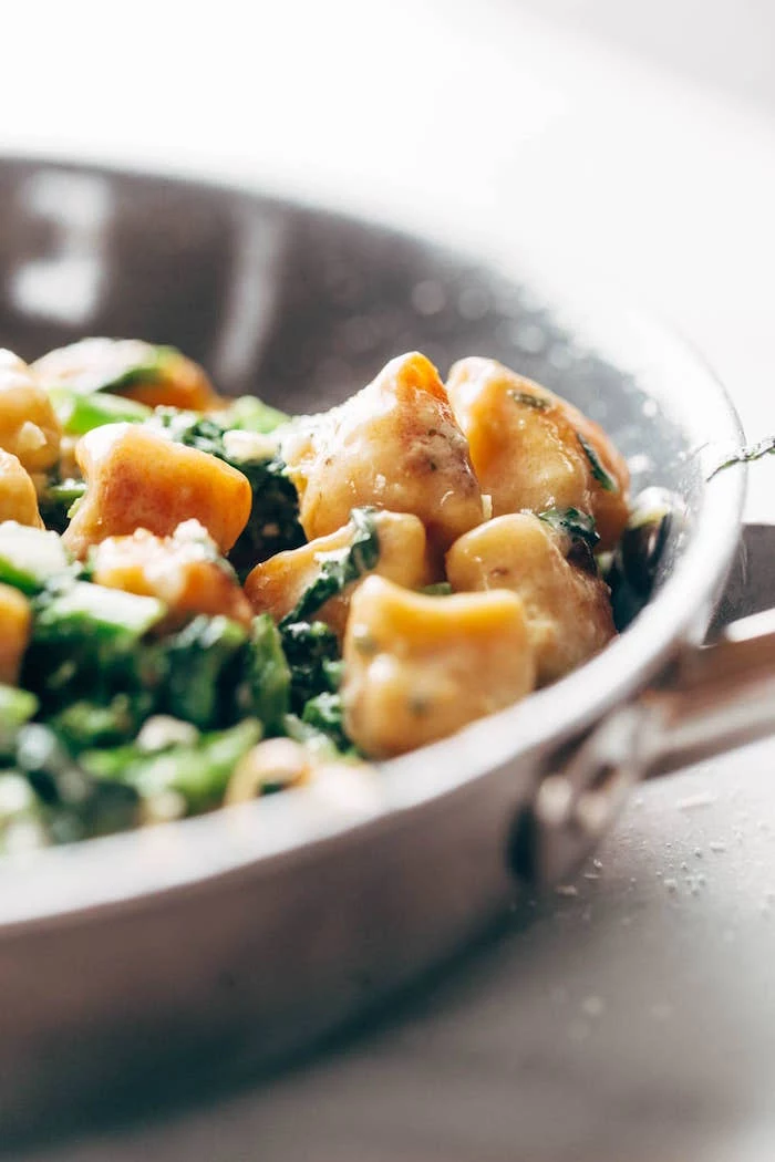 sweet potato gnocchi and kale cooking in metal pan recipes using gnocchi placed on white surface
