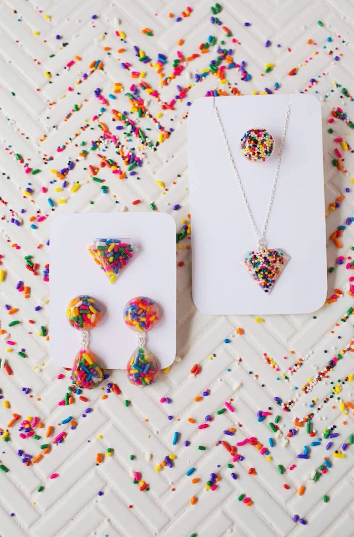 two separate sets of jewelry made with resin and colorful sprinkles resin jewelry kit earrings necklace rings