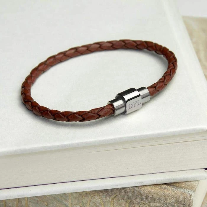 valentines gifts for him brown leather bracelet with personalised clip with three initials placed on white table