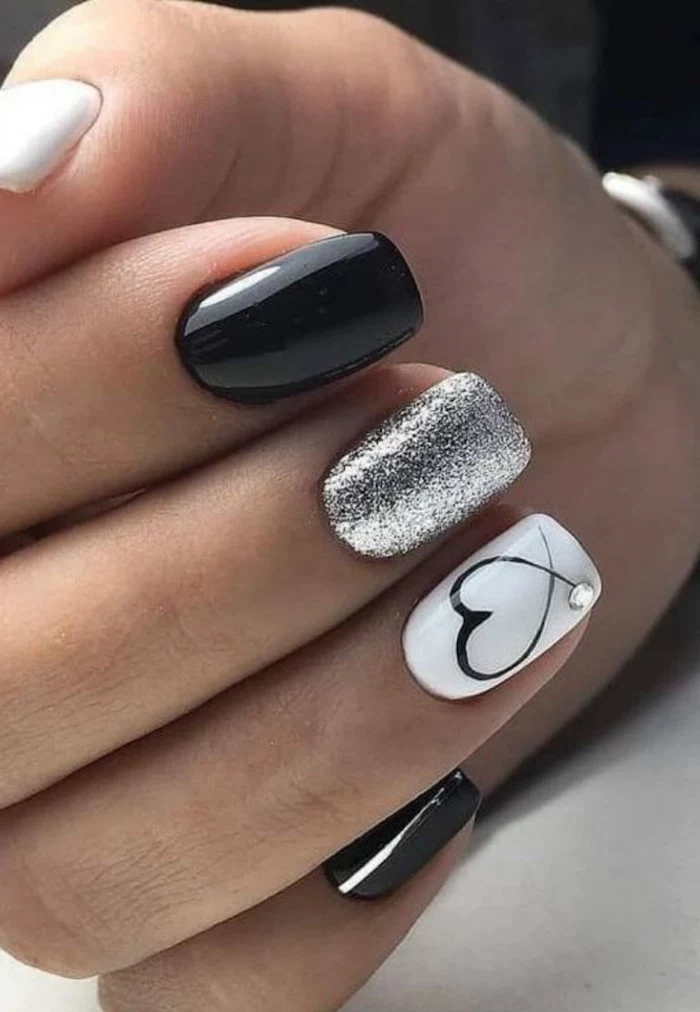 valentines nails black white and silver glitter nail polish on short squoval nails black heart drawn on ring finger