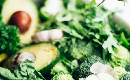 white bowl full of green vegetables placed on marble surface inflammatory foods acovado broccoli kale spinach arugula