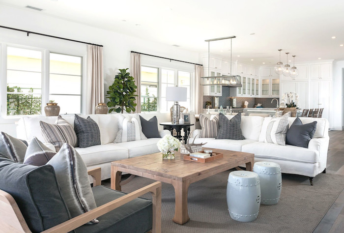 white sofas with gray white throw pillows gray armchair large wooden coffee table coastal home decor