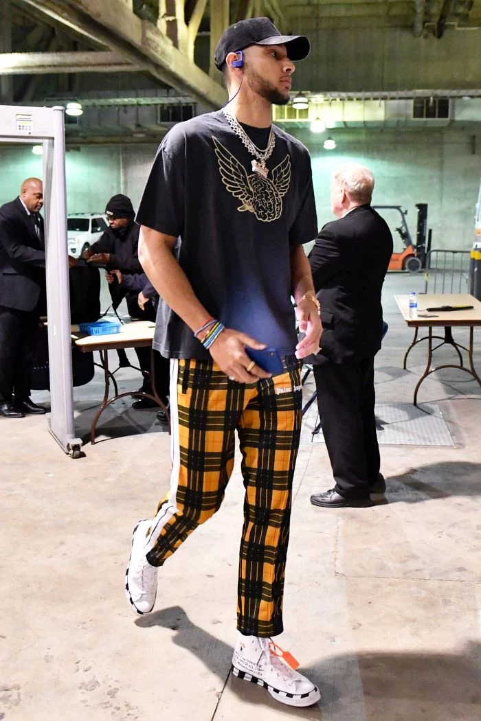 ben simmons wearing yellow and black pants black t shirt and hat hip hop clothing white sneakers