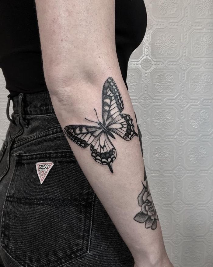 black and white butterfly on the side of the arm under the elbow butterfly and flower tattoo black and white photo