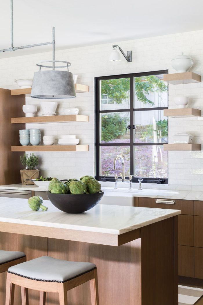 black bowl on wooden kitchen island wood floating shelves kitchen wooden cabinets white countertops tiled white backdrop