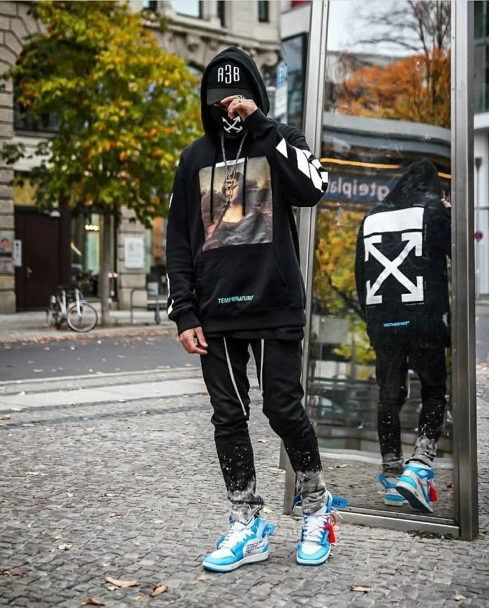 black hoodie and jeans worn by man on the street with blue and white sneakers streetwear outfits off white