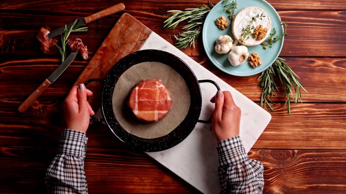 brie cheese wrapped in prosciutto placed on paper lined baking tray finger foods for party