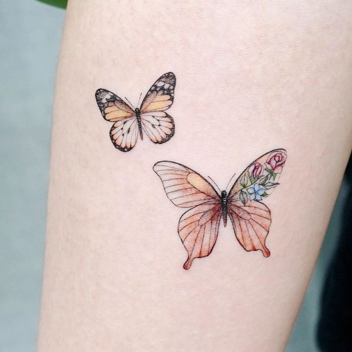 butterfly tattoo meaning two colored butterflies with flowers forearm tattoo