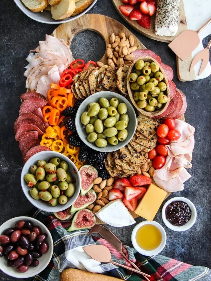 charcuterie board cheese pickled olives in bowls with crackers meats cheeses veggies and fruits