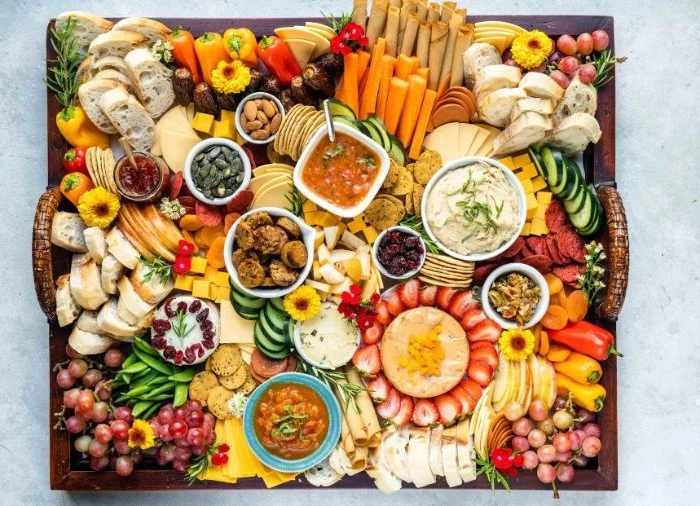 charcuterie board ideas large wooden tray filled with different types of cheese meat fruits veggies jams