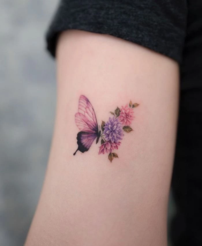 colored butterfly tattoo inside the arm small butterfly tattoo half purple half flowers in pink and purple