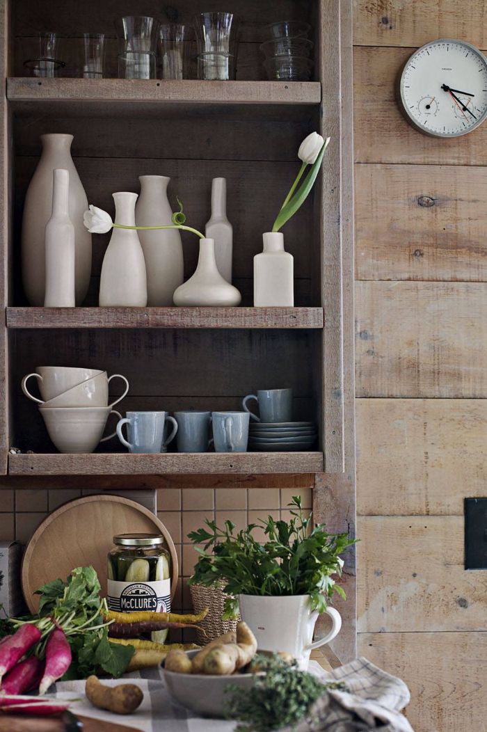 dark wooden backdrop open kitchen cabinets made of wood with glasses mugs and vases