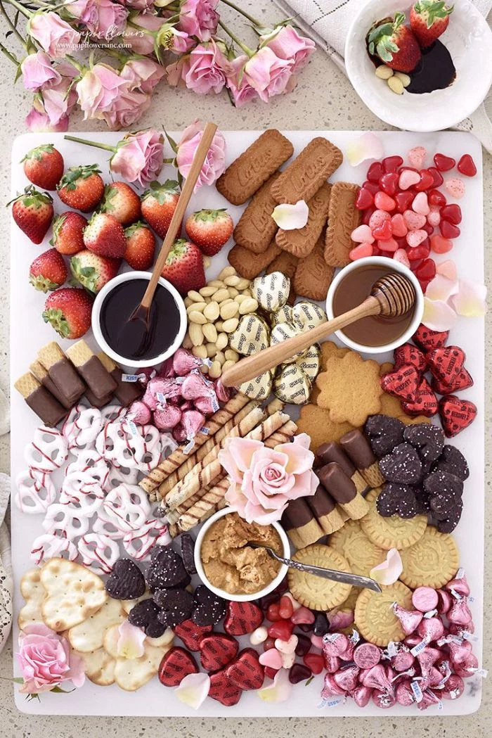 dessert charcuterie board ideas with cookies chocolate crachers strawberries candy arranged on white plate