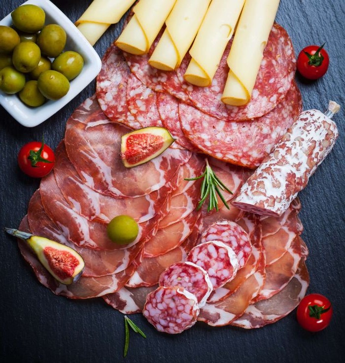 different types of meat rolled up cheese olives cherry tomatoes cheese board ideas arranged on black tray