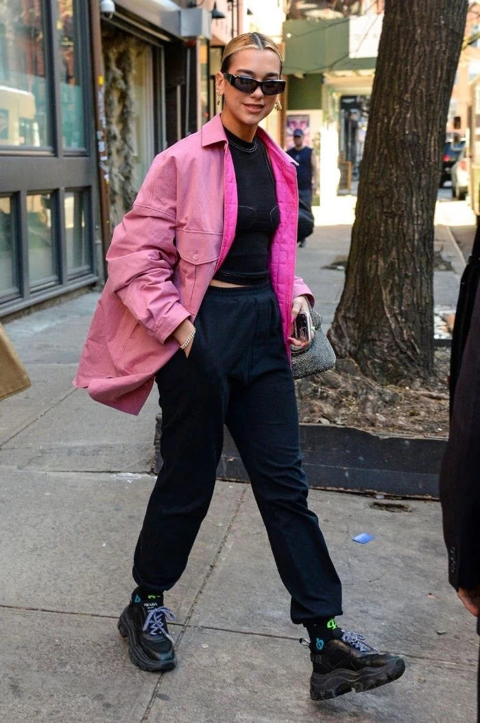 dua lipa wearing black jogging pants black top pink jacket streetwear clothing black sneakers