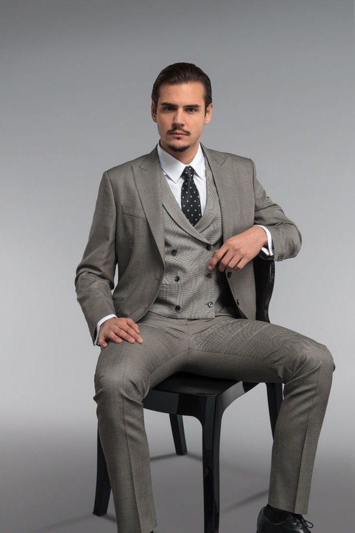 grisaille suit three piece suit worn with white shirt black tie by man sitting on black chair fabrics for suits