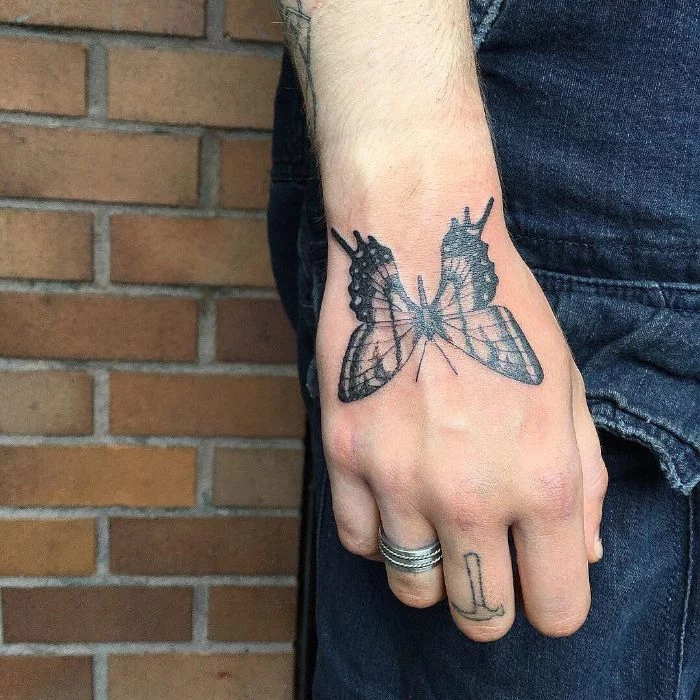 hand tattoo butterfly tattoo meaning black and white butterfly on man wearing jeans
