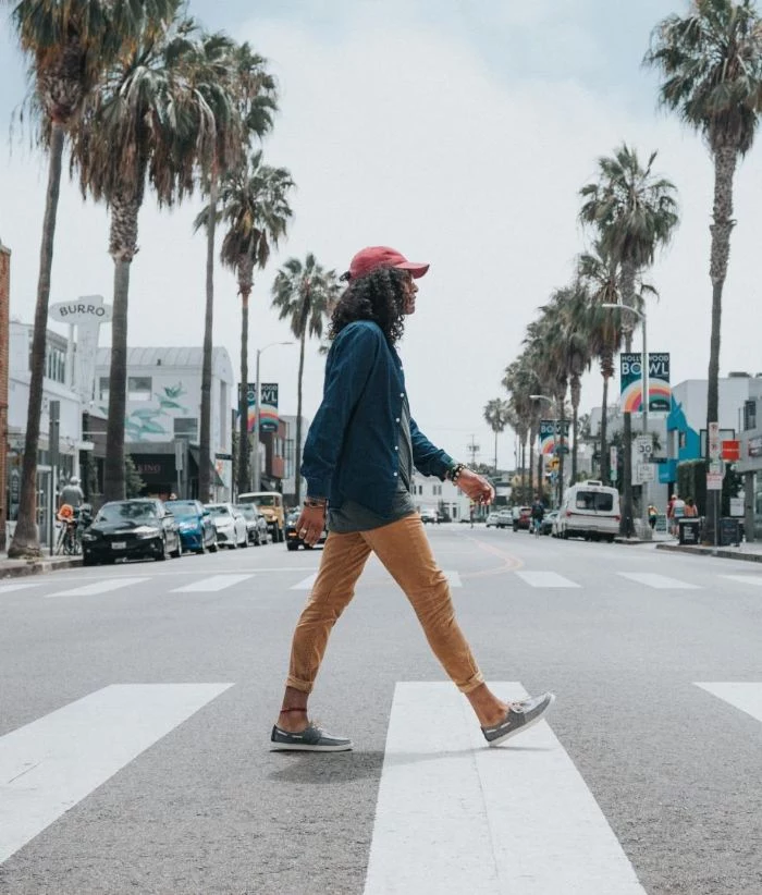 hip hop clothing man walking on the street wearing yellow pants blue t shirt red cap