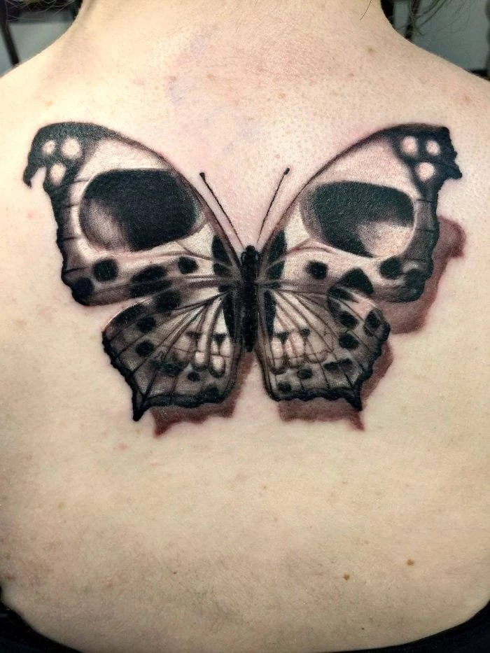 large back tattoo butterfly and flower tattoo black and white butterfly with skull like eyes