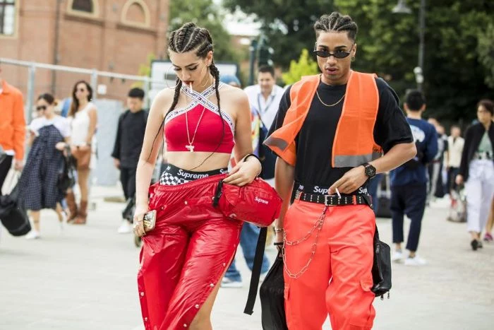 man and woman walking down the street mens streetwear red and orange leather pants red and black tops