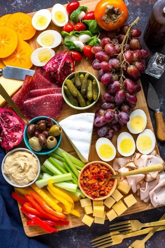 meat cheeses boiled eggs veggies fruits what is a charcuterie board arranged on wooden board