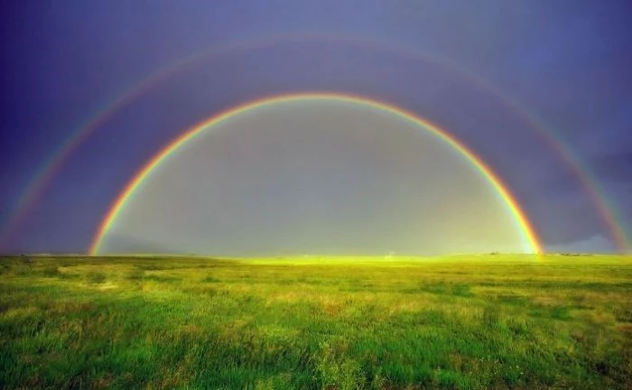 photo of a field covered with green grass blue sky above it cute rainbow wallpaper two rainbows in the sky