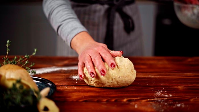 potato dough being kneaded on floured wooden surface easy party appetizers