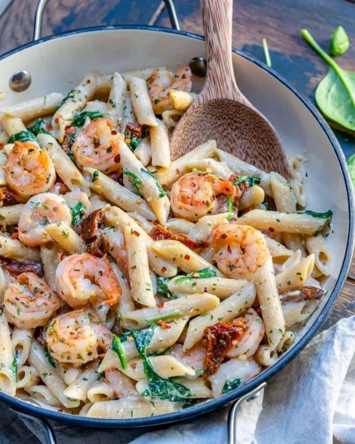 shrimp pasta with creamy sauce garnished with parsley how to make pasta from scratch wooden spoon on the side