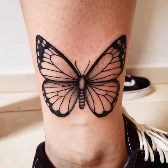 side of the ankle tattoo butterfly hand tattoo black and white butterfly on woman wearing black sneakers