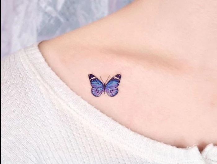 small blue butterfly under the collarbone butterfly tattoo woman wearing white blouse