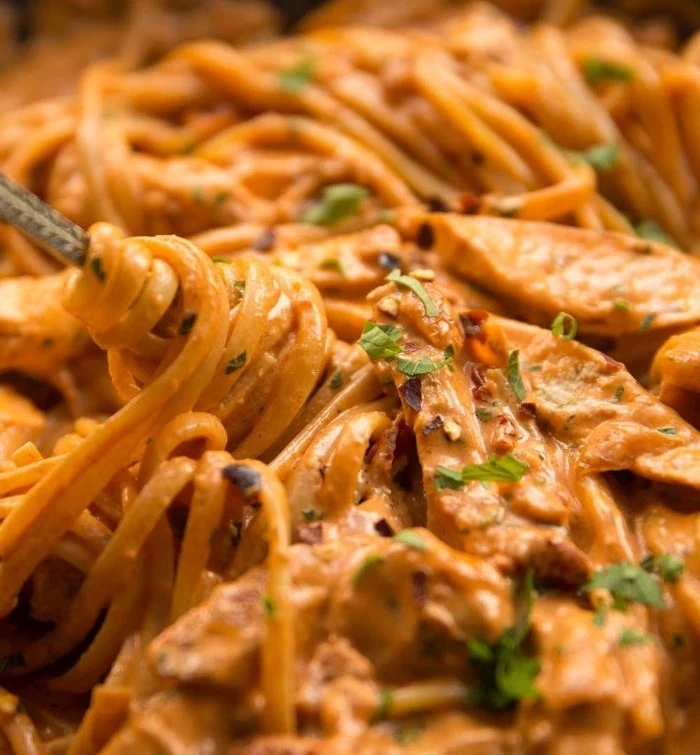 spicy chicken pasta cooked in creamy sauce homemade pasta dough garnished with parsley