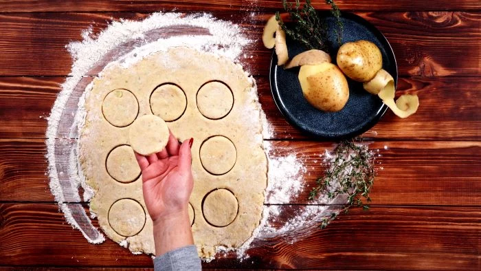 spread out potato dough on floured wooden surface easy party appetizers small round pieces cut out