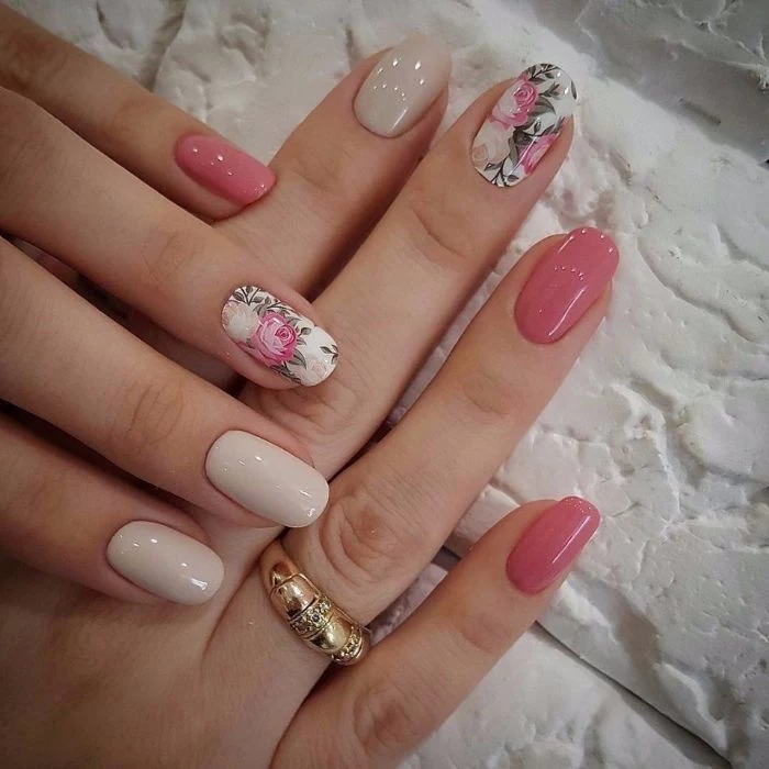 spring nail colors 2021 pink and light gray nail polish floral decorations on middle and ring fingers on almond nails
