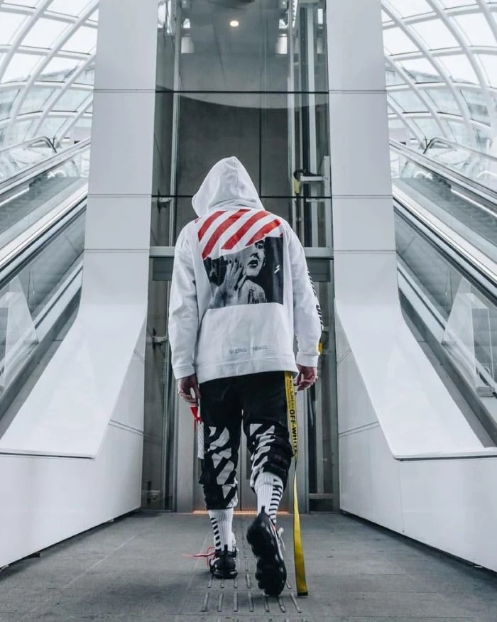 streetwear fashion man wearing all off white outfit white hoodie black pants black sneakers